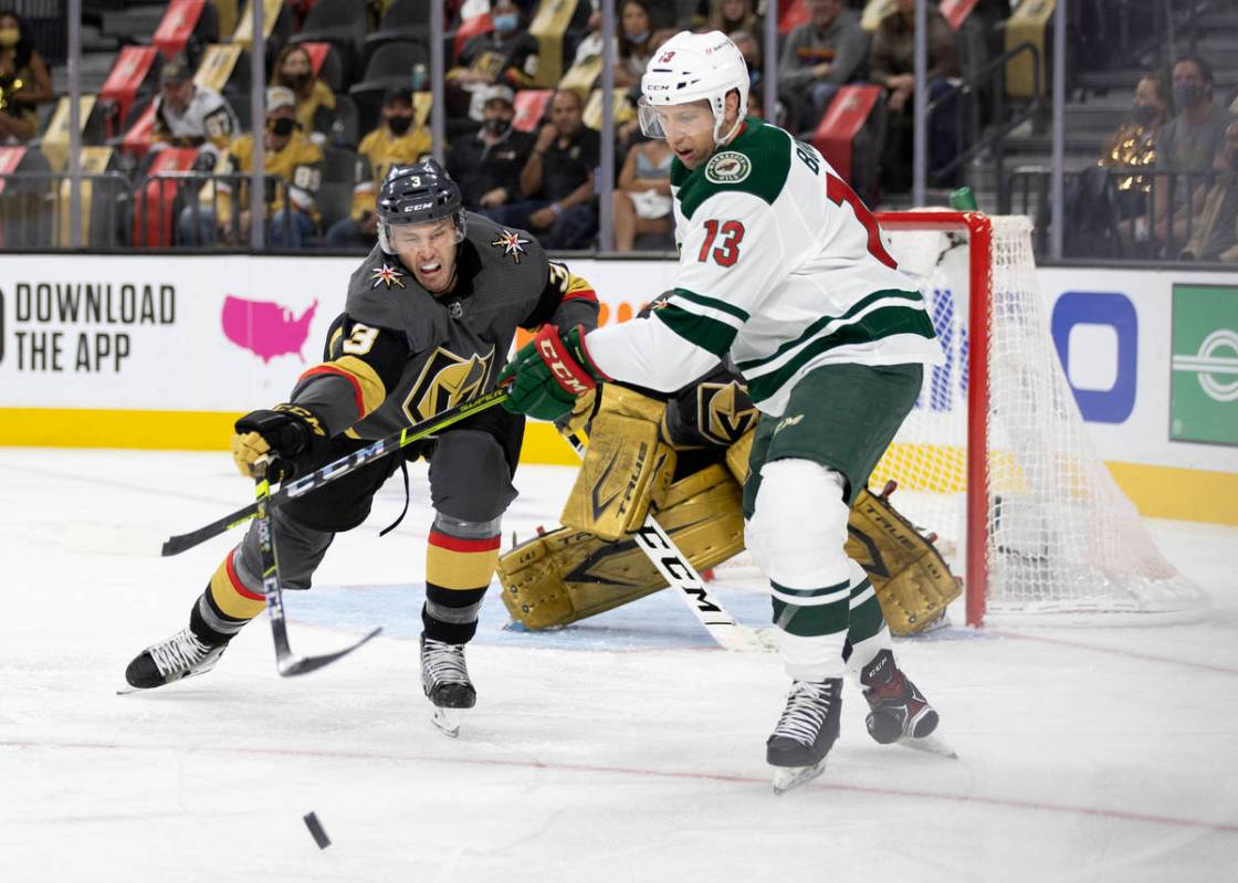 Golden Knights defenseman Brayden McNabb (3) and Wild center Nick Bonino (13) compete for the p ...