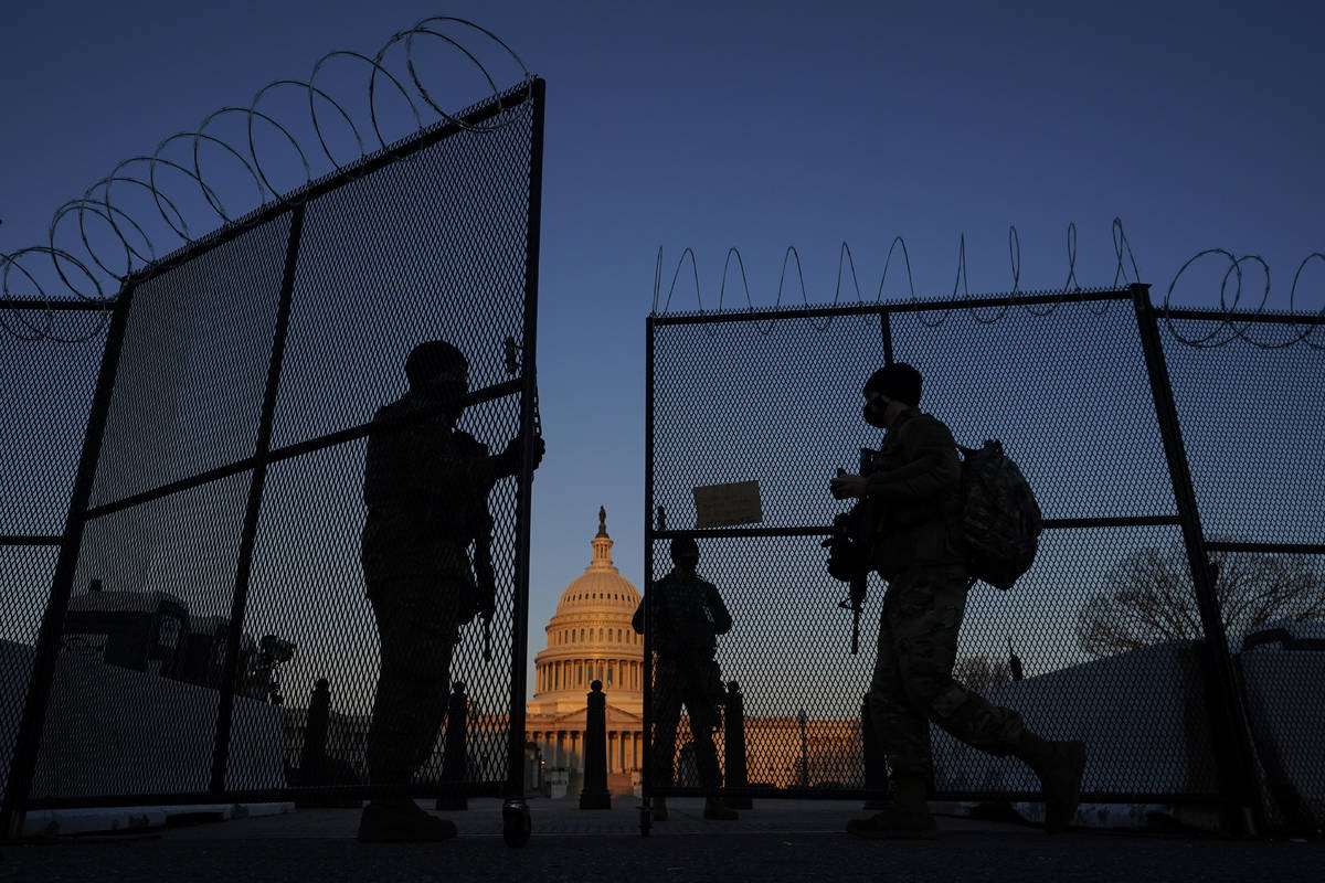 In this March 8, 2021, file photo, members of the National Guard open a gate in the razor wire ...