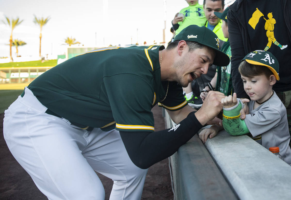 Oakland Athletics catcher Collin Theroux, left, signs the cast of Charleston Kenton, 6, at the ...