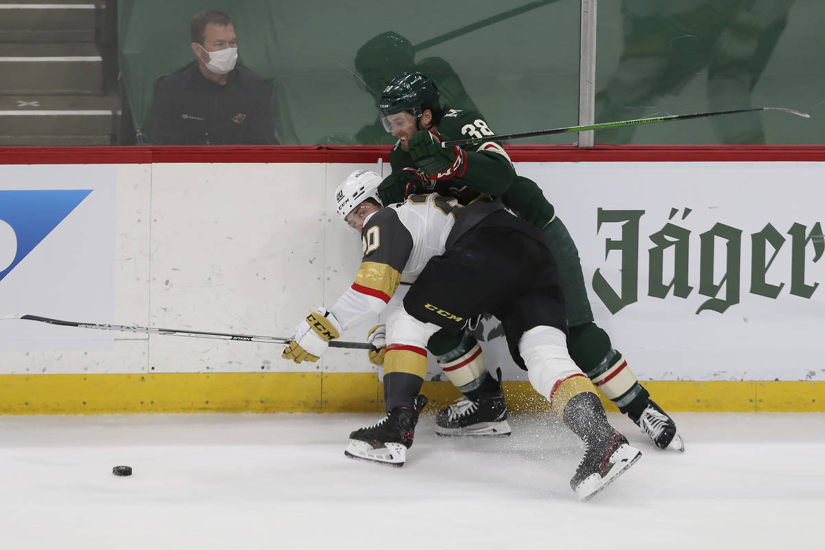 Vegas Golden Knights' Chandler Stephenson (20) and Minnesota Wild's Ryan Hartman (38) go after ...