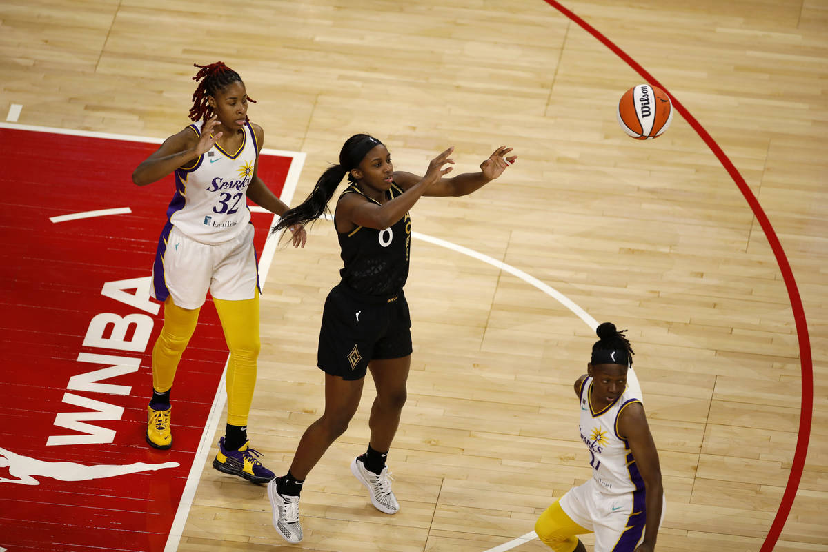 Las Vegas Aces guard Jackie Young (0) passes the ball past Los Angeles Sparks guard Bria Holmes ...