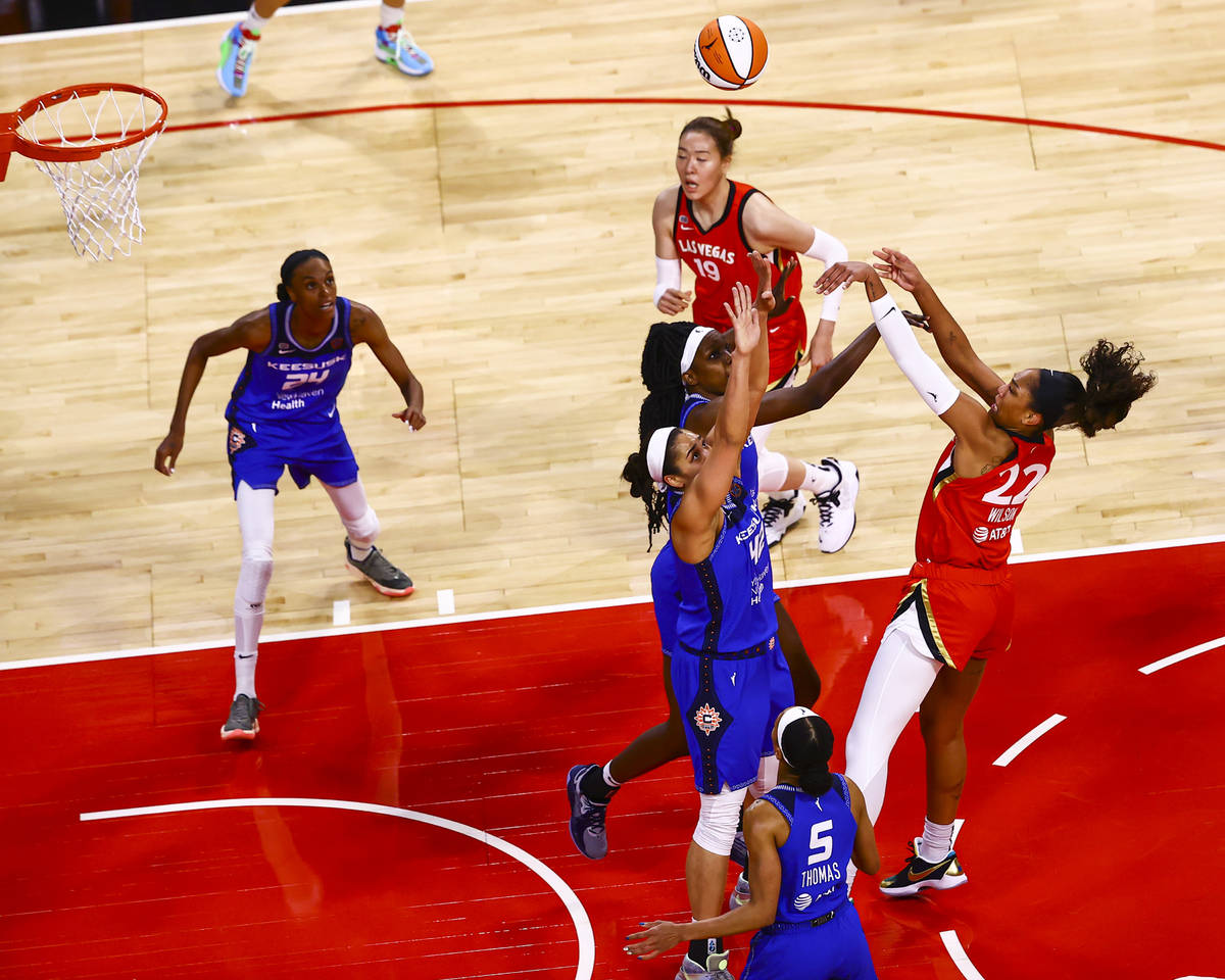 Las Vegas Aces' A'ja Wilson (22) shoots over Connecticut Sun's Beatrice Mompremier (1) and Brio ...