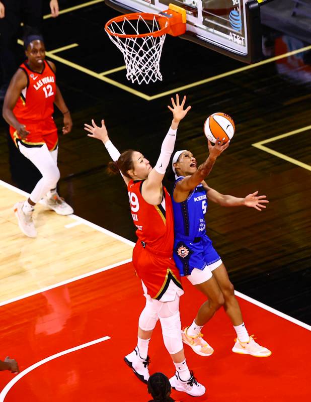 Connecticut Sun's Jasmine Thomas (5) shoots under pressure from Las Vegas Aces' JiSu Park (19) ...