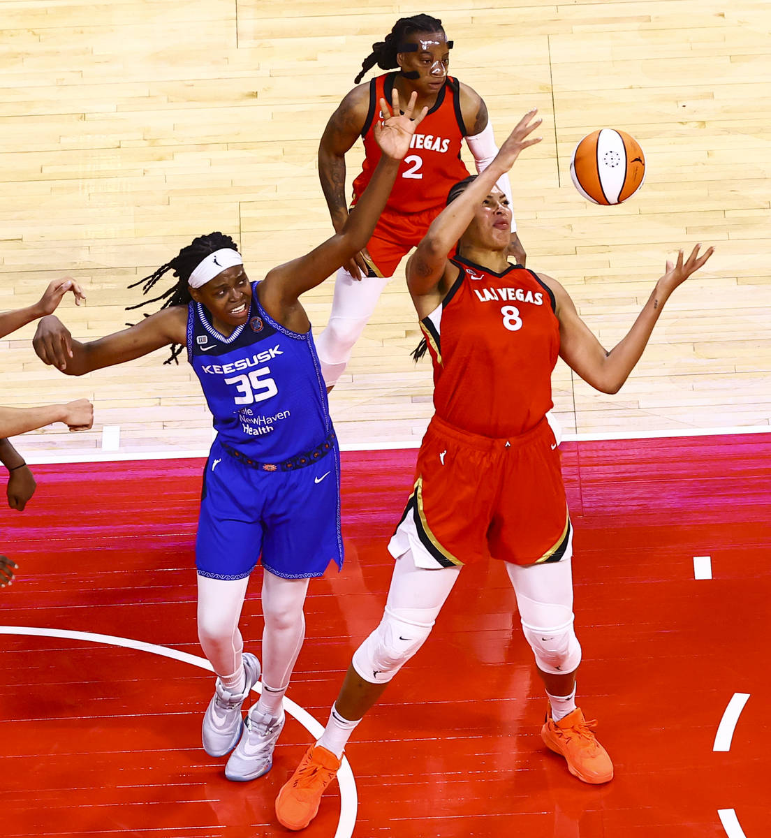 Las Vegas Aces' Liz Cambage (8) grabs a rebound in front of Connecticut Sun's Jonquel Jones (35 ...