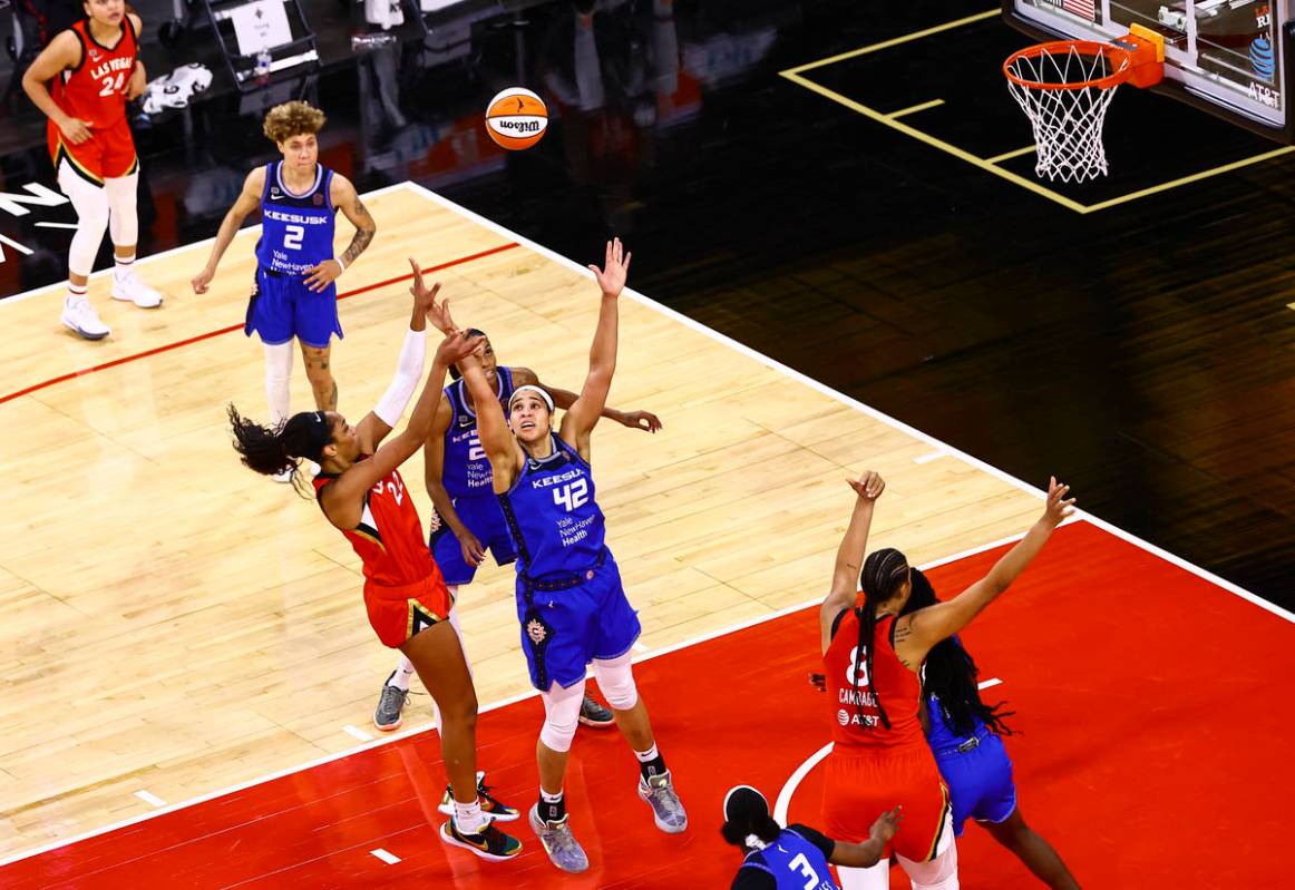 Las Vegas Aces' A'ja Wilson (22) shoots over Connecticut Sun's Brionna Jones (42) during the th ...