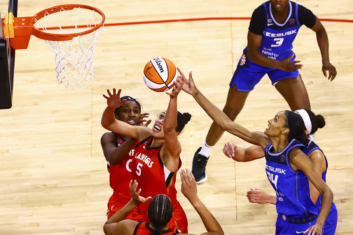 Las Vegas Aces' Dearica Hamby (5) goes for a rebound in front of Connecticut Sun's DeWanna Bonn ...