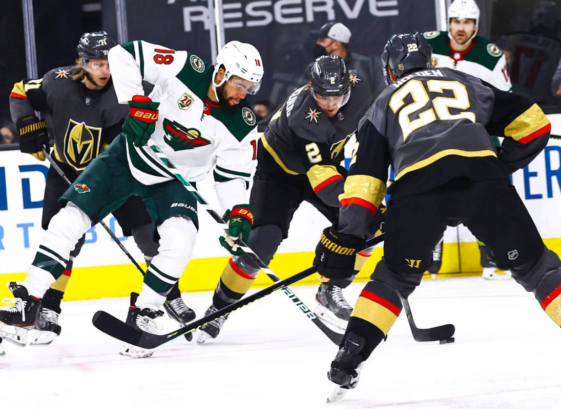 Golden Knights' defenseman Zach Whitecloud (2) skates with the puck under pressure from Minneso ...