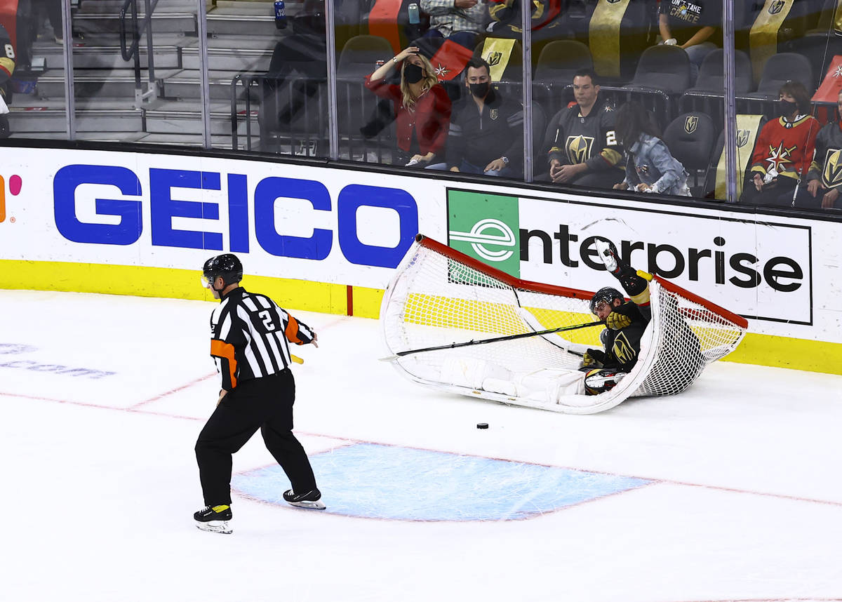 Golden Knights' Alex Pietrangelo gets tripped up in the net after an empty net goal by Minnesot ...