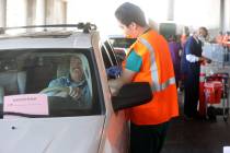 David Butler of Las Vegas gets his shot from Leo Chen during a drive-thru COVID-19 vaccine clin ...