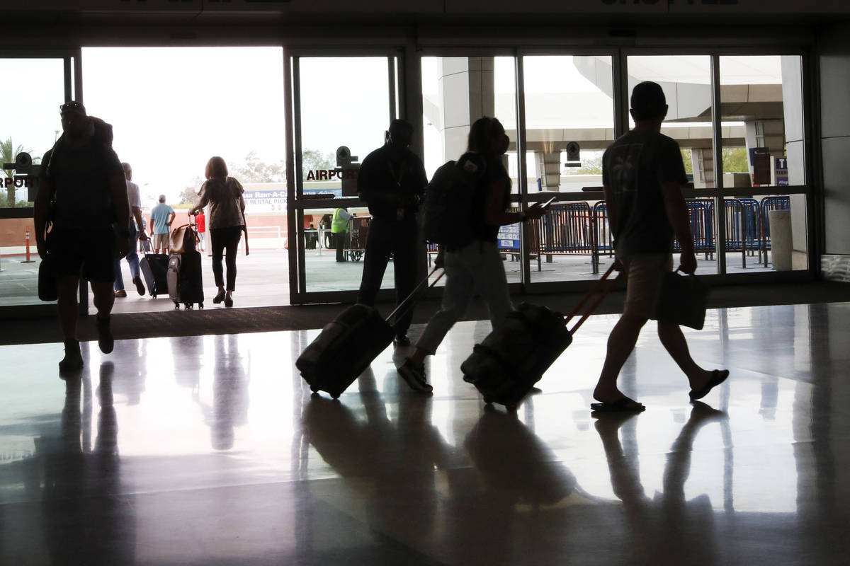 Travelers walk through the McCarran Rent-A-Car Center in Las Vegas, Tuesday, May 25, 2021. (Chi ...