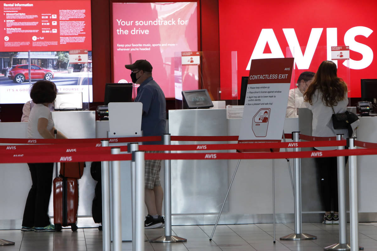 Travelers wait to get a rental car at an Avis car rental in the McCarran Rent-A-Car Center in L ...