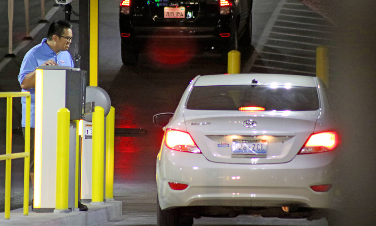 An employee watches a customer pay for parking near the parking garage exit at the Cosmopolitan ...