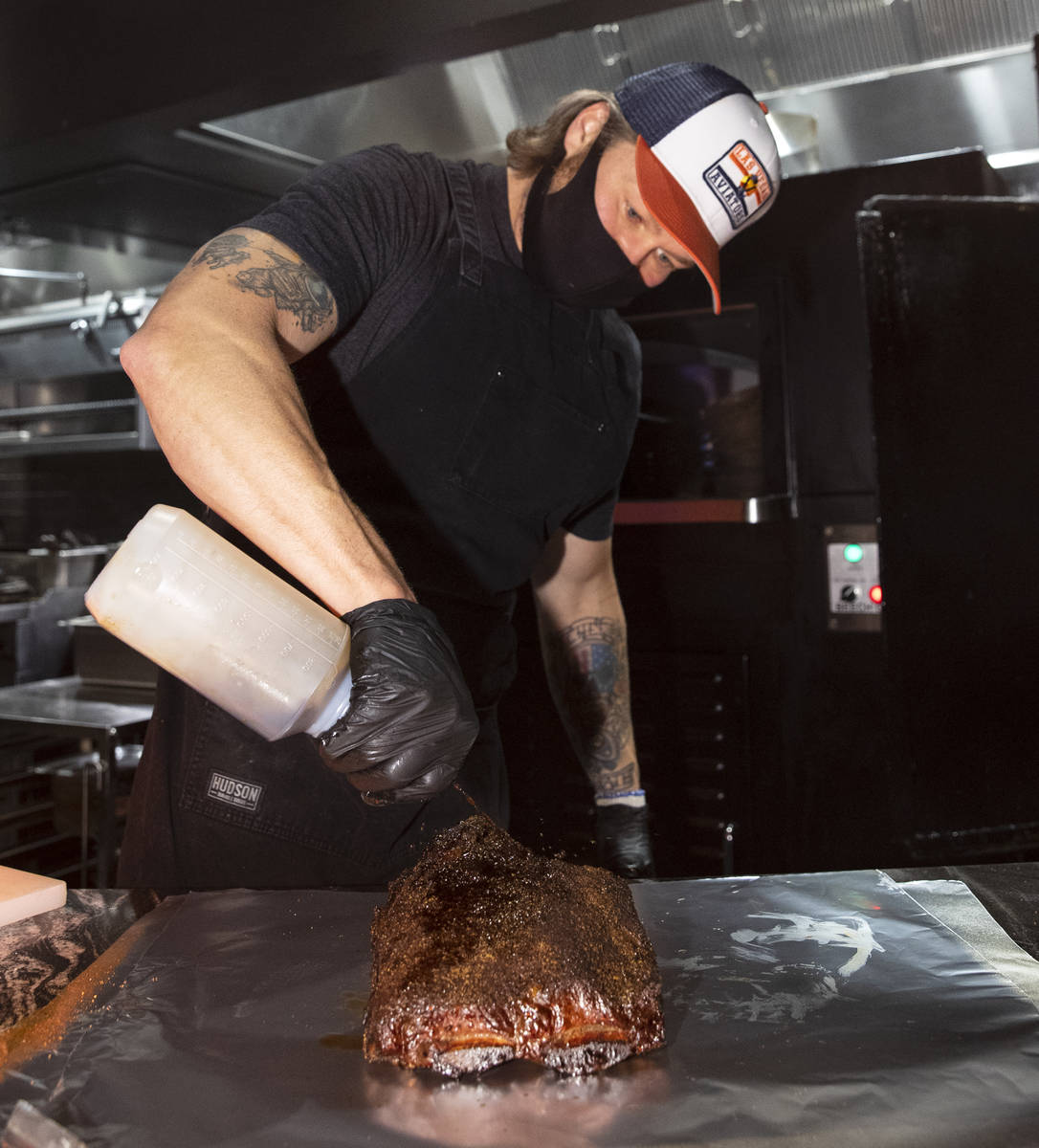 Joe Woodel, BBQ pitmaster, marinates smoked beef ribs at The Beast by Todd English, Area15 food ...