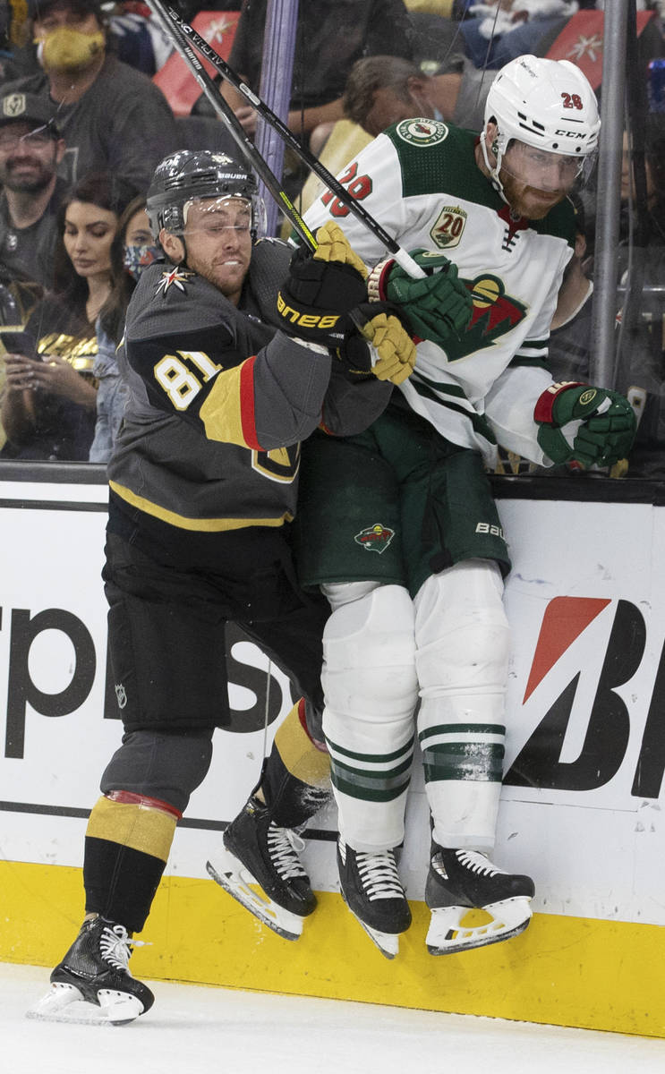 Vegas Golden Knights center Jonathan Marchessault (81) checks Minnesota Wild defenseman Ian Col ...