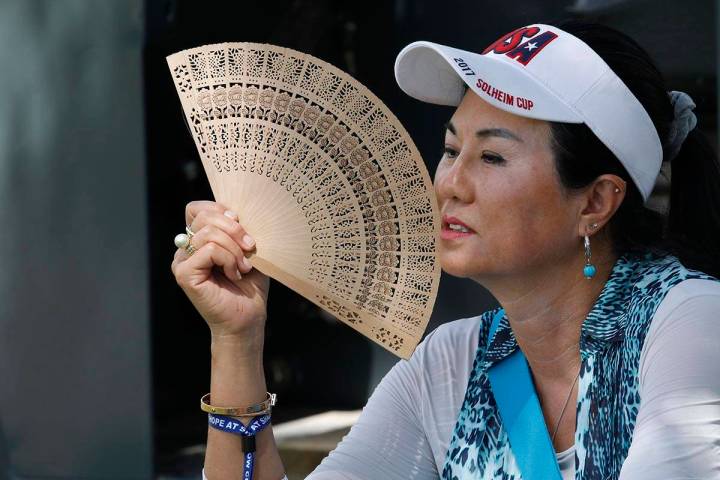 Danielle Kang's mother, Grace Lee, uses a folding fan while waiting on the eighth green to see ...