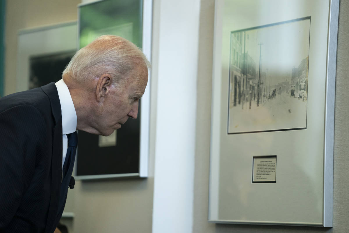 President Joe Biden looks at a photograph during a tour of the Greenwood Cultural Center to mar ...