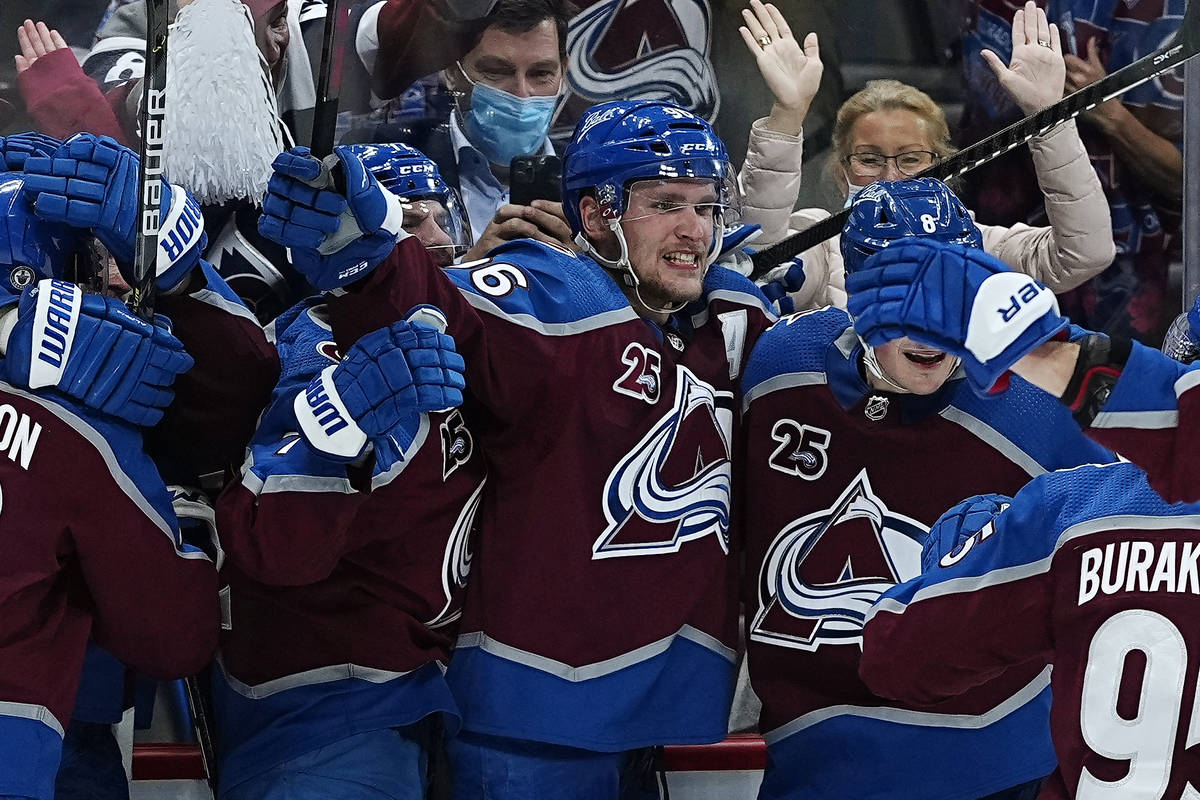 Colorado Avalanche right wing Mikko Rantanen, center, is congratulated by teammates after scori ...