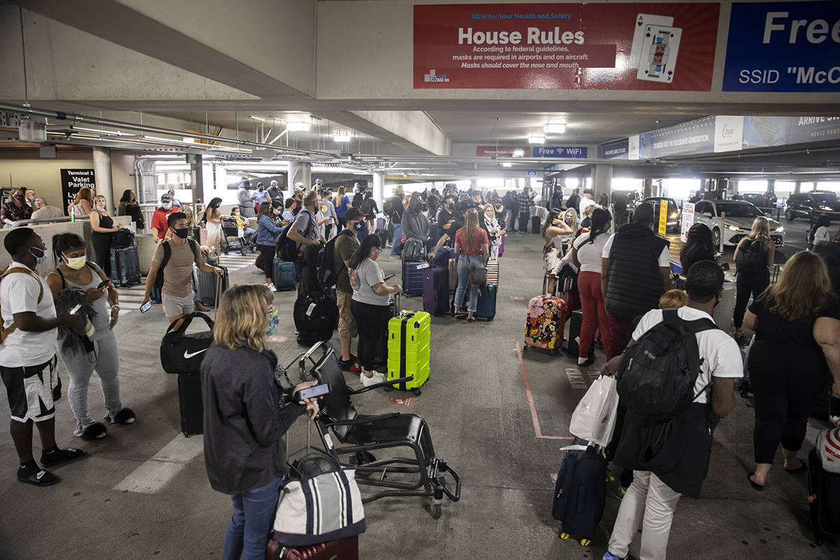 People wait for their ride at McCarran International Airport's Terminal 1 ride share waiting ar ...