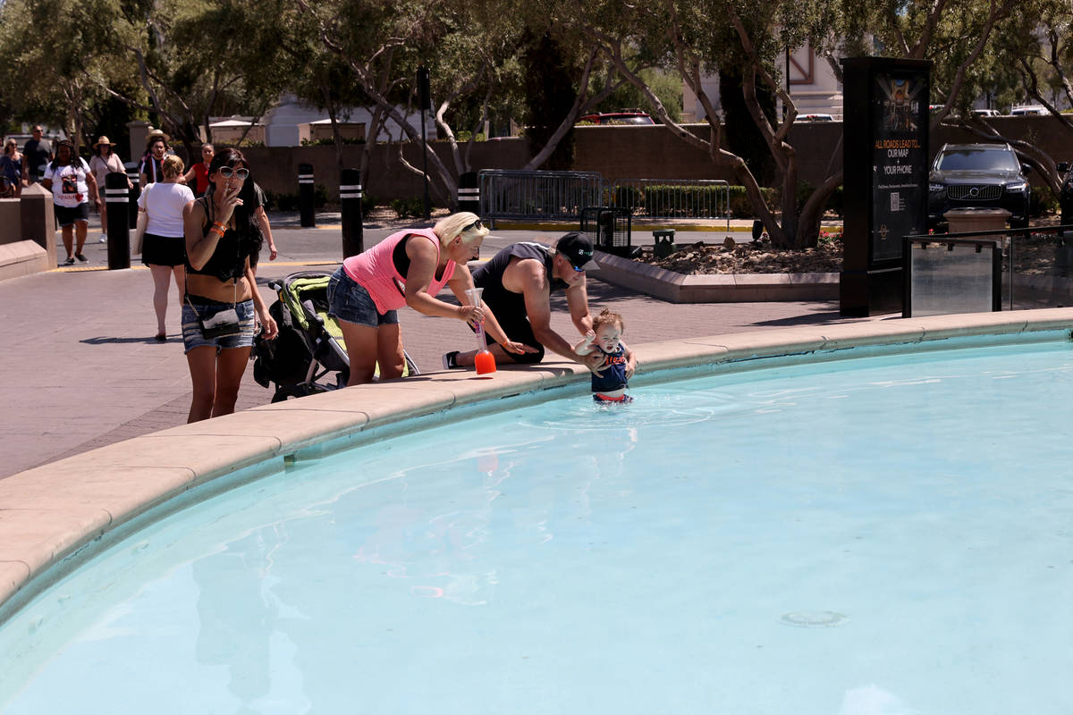 Kevin Smith of Clinton, Utah dips his son Ryan, 2, in a fountain in front of Caesars Palace on ...