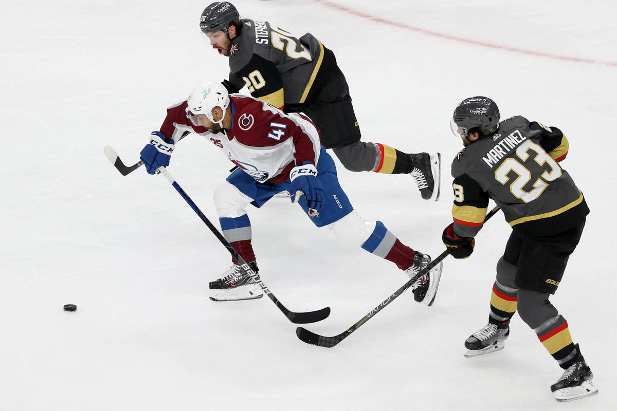 Vegas Golden Knights center Chandler Stephenson (20) and defenseman Alec Martinez (23) defend a ...