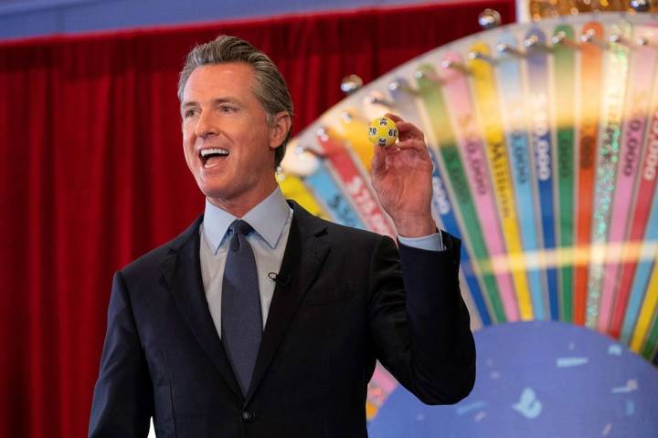 California Gov. Gavin Newsom holds up a lottery ball at the California Lottery Headquarters on ...