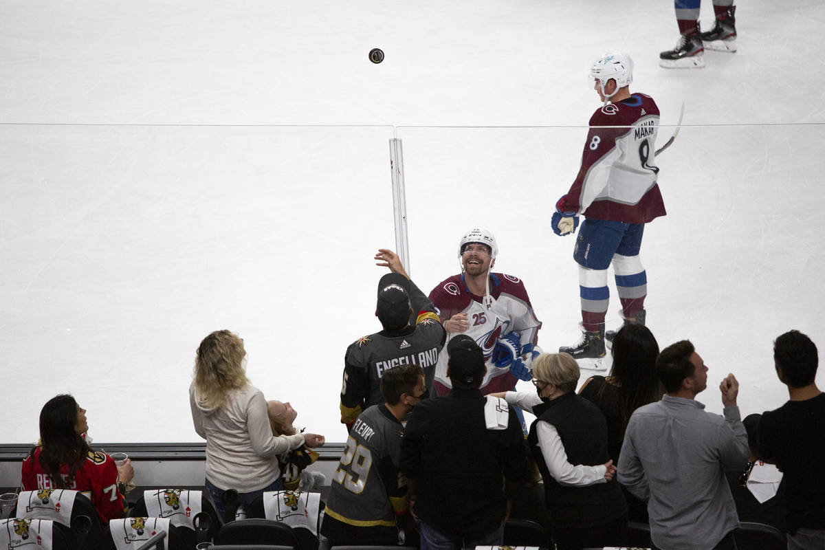 Avalanche right wing Logan O'Connor (25) tosses a puck to fans before Game 3 of a second-round ...