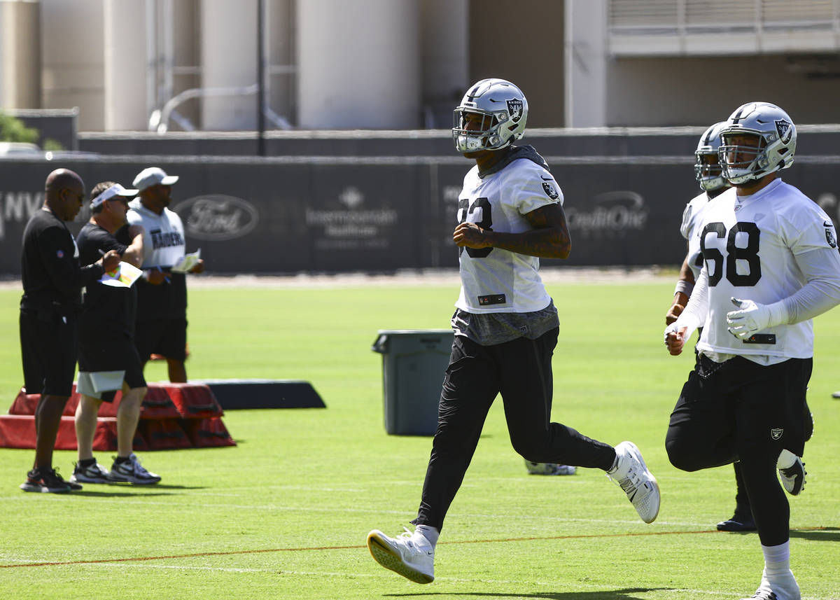 Raiders tight end Darren Waller (83) warms up alongside offensive lineman Andre James (68) duri ...