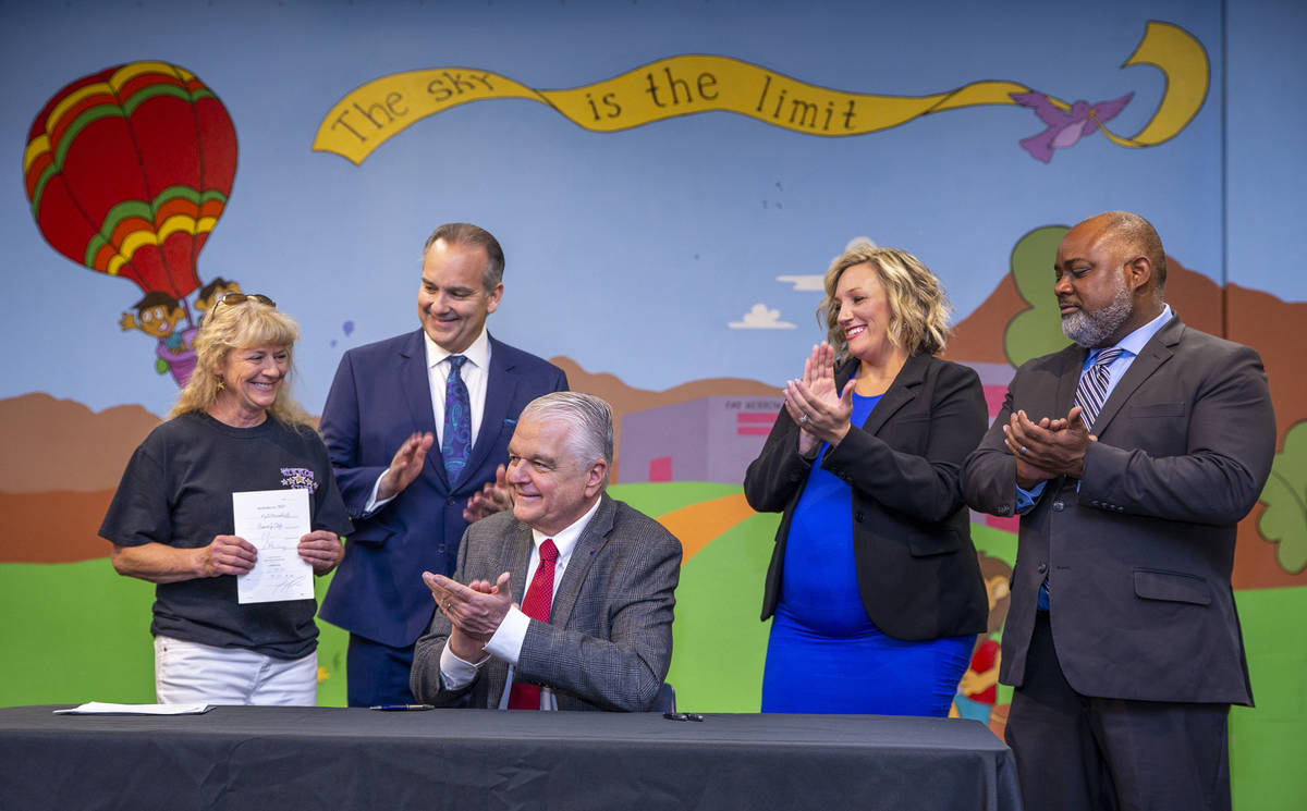 (From left) Principal Judy Jardahl holds Senate Bill #450 while applauded by Clark County Schoo ...