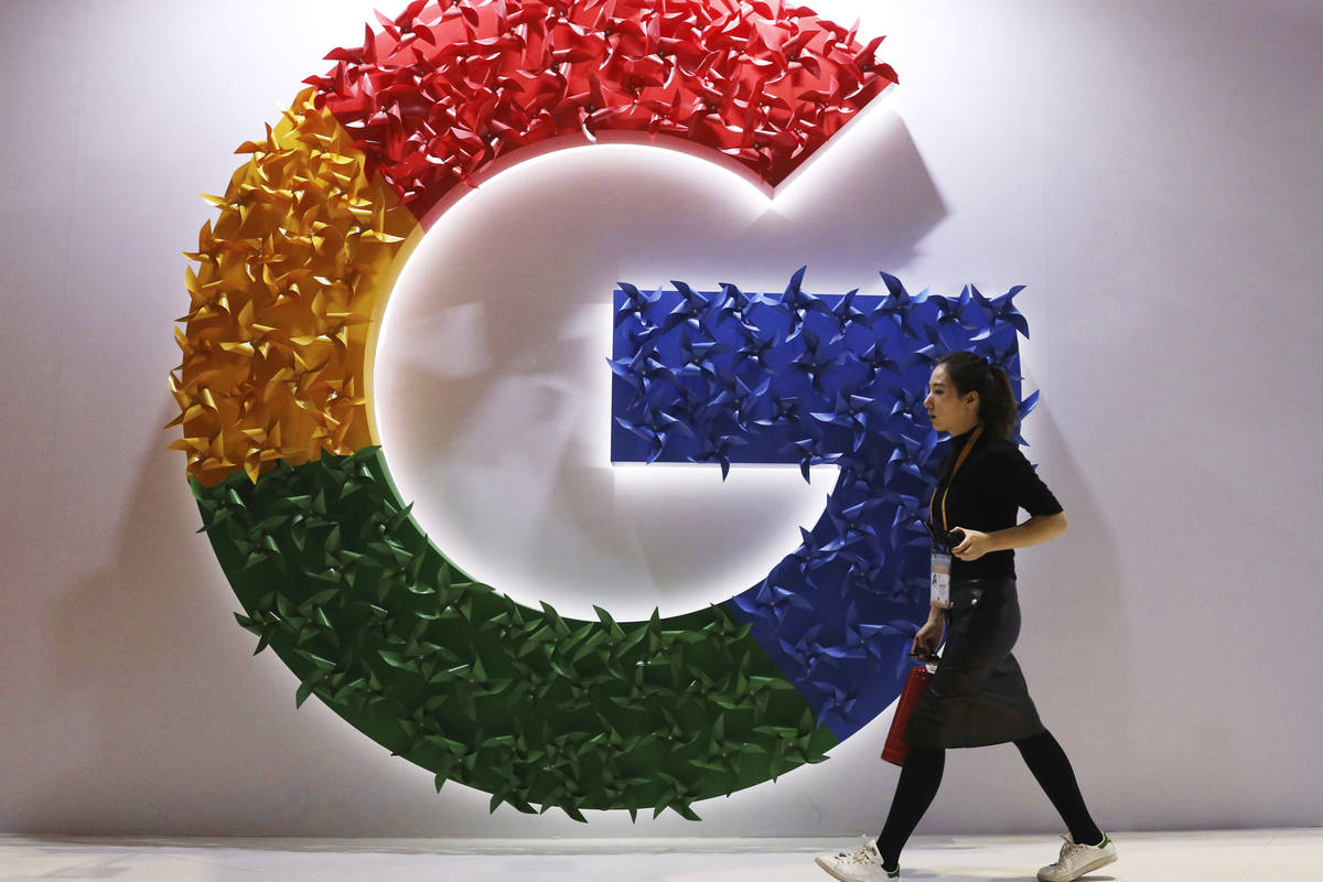 In this Monday, Nov. 5, 2018 file photo, a woman walks past the logo for Google at the China In ...