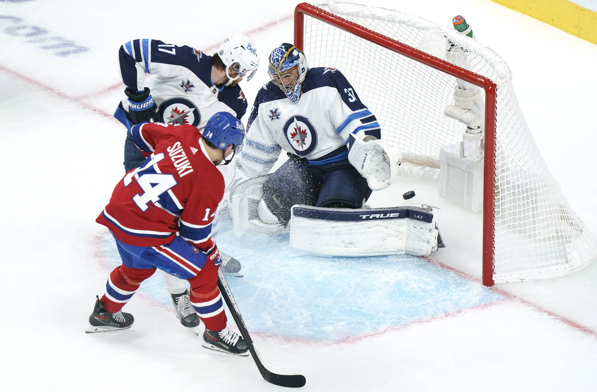 Montreal Canadiens' Nick Suzuki score a power play goal past Winnipeg Jets goaltender Connor He ...