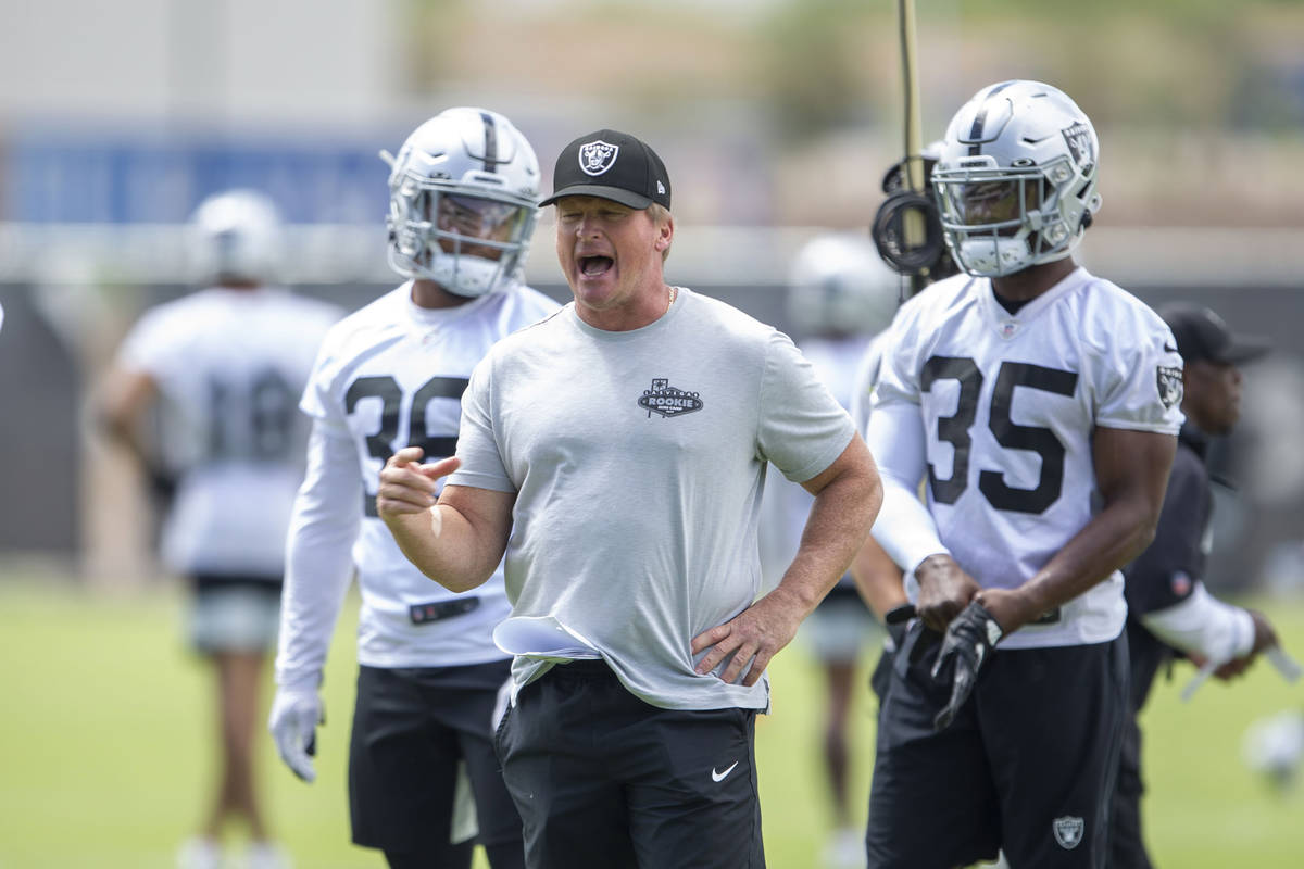 Raiders coach Jon Gruden gives instruction during drills as running backs Trey Ragas (36) and T ...