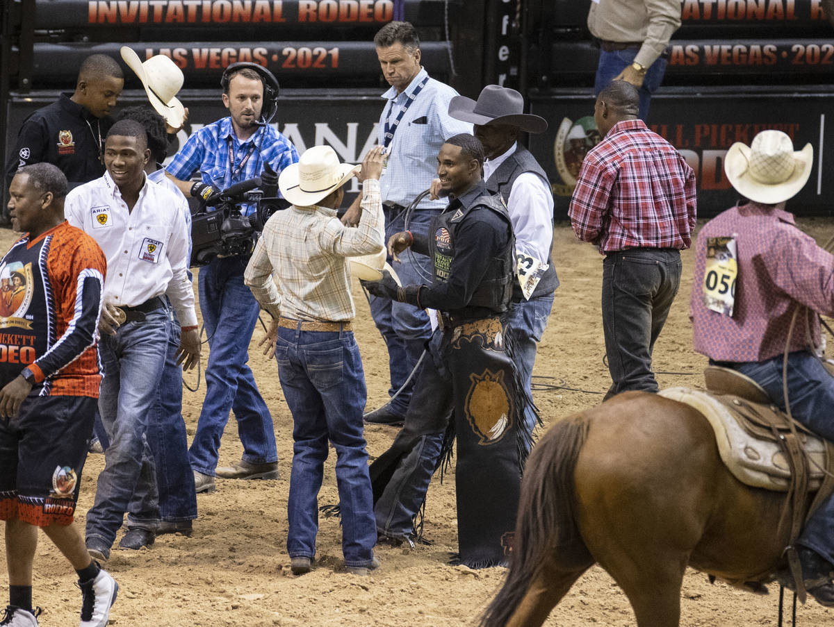 Winner of Bull Riding competition, Ouncie Mitchell, of Houston, Texas., center, congratulated ...