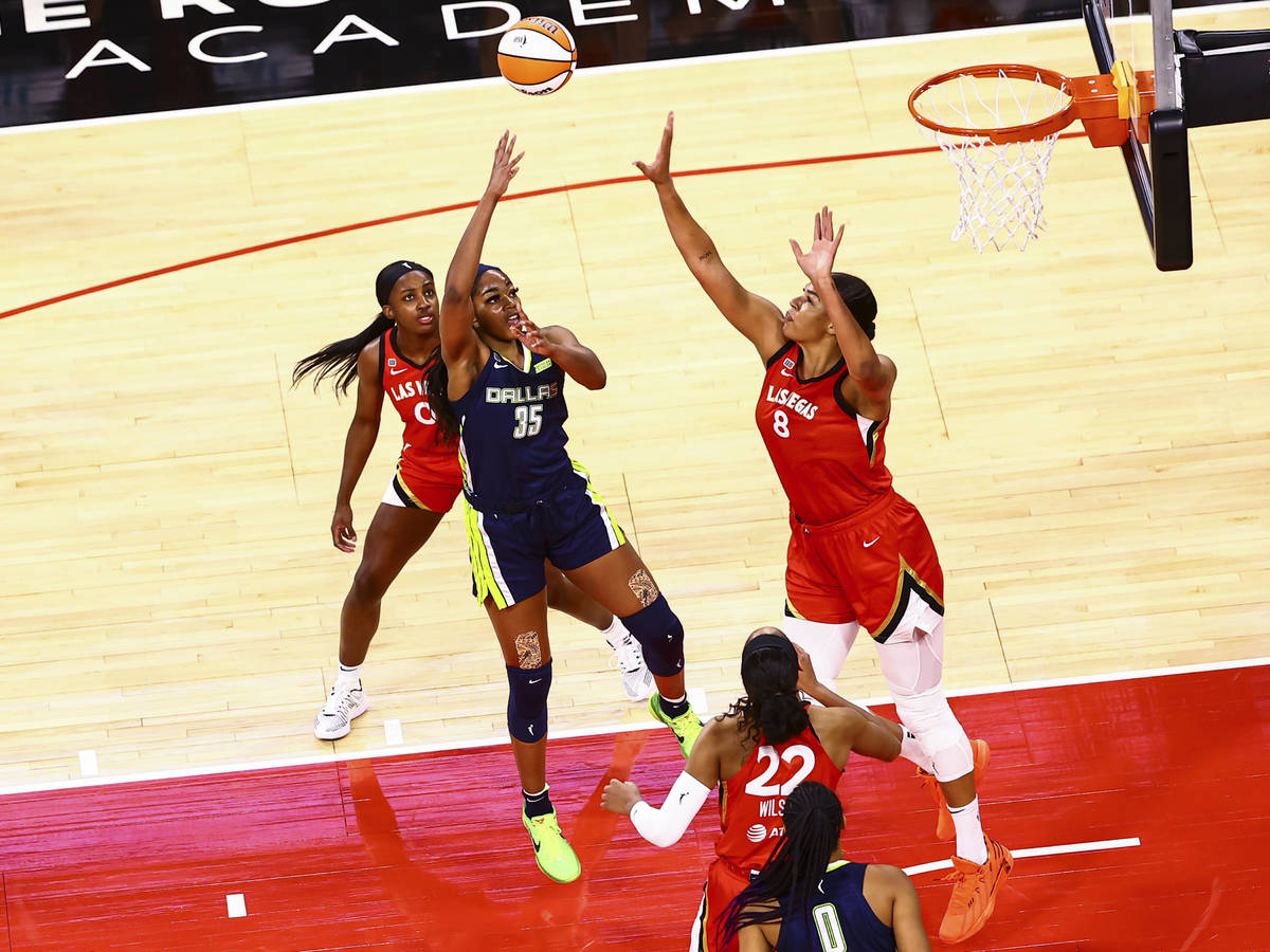Dallas Wings' Charli Collier (35) shoots under pressure from Las Vegas Aces' Liz Cambage (8) as ...