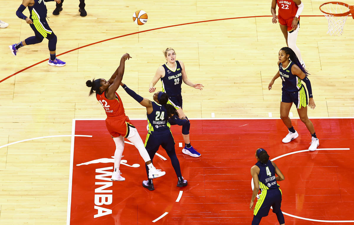 Las Vegas Aces' Chelsea Gray (12) shoots over Dallas Wings' Arike Ogunbowale (24) during the th ...