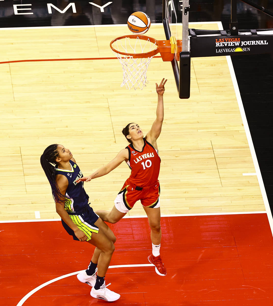 Las Vegas Aces' Kelsey Plum (10) goes to the basket in front of Dallas Wings' Satou Sabally (0) ...