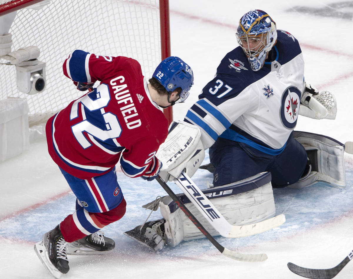 Winnipeg Jets goaltender Connor Hellebuyck (37) stops Montreal Canadiens right wing Cole Caufie ...