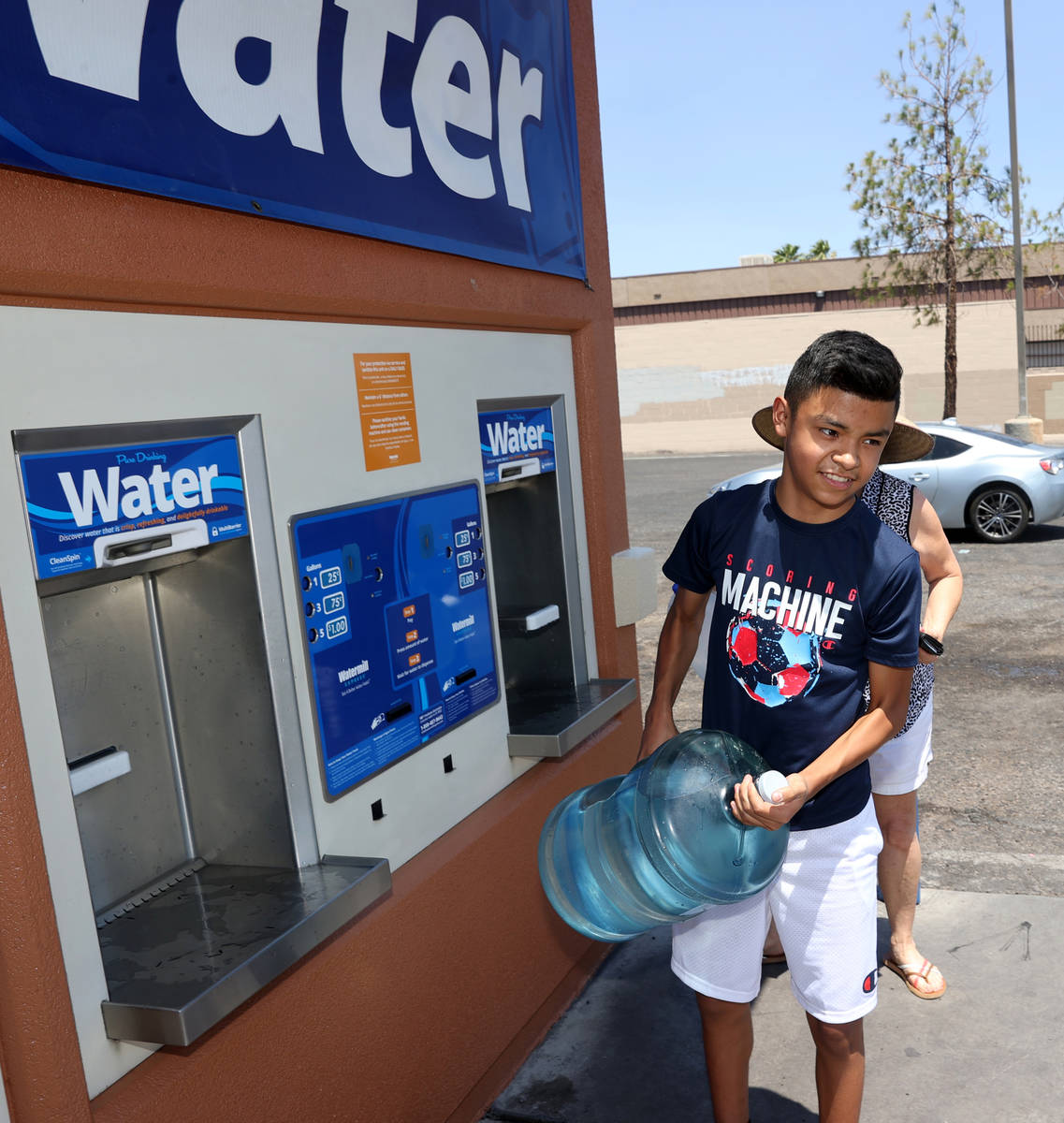 Miguel Lazcano, 14, gets water at a kiosk on the corner of Smoke Ranch Road and Jones Boulevard ...