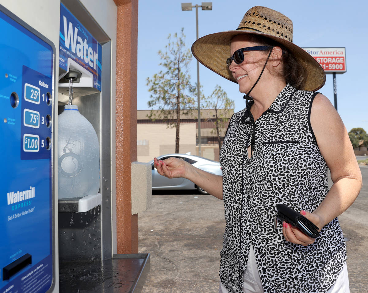 Laurie Baron, 64, gets water at a kiosk on the corner of Smoke Ranch Road and Jones Boulevard M ...