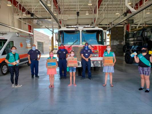 This undated photo provided by Girl Scouts of New Mexico Trails shows scouts donating cookies t ...