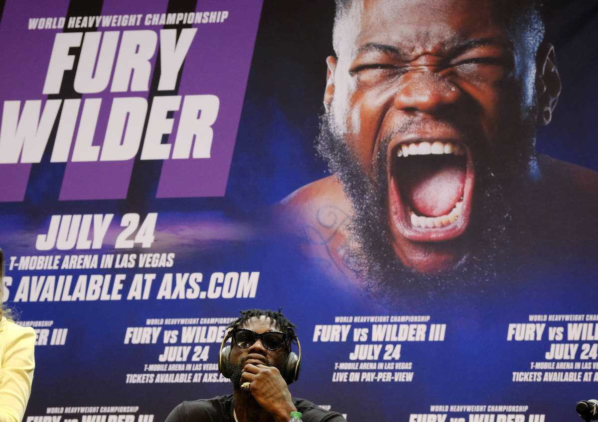 Deontay Wilder wears headphones while sitting during a news conference in Los Angeles on Tuesda ...