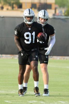 Raiders defensive ends Yannick Ngakoue (91) run a drill with Maxx Crosby (98) during their NFL ...