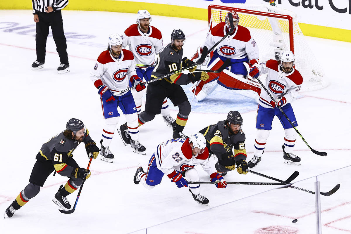 Golden Knights' Alec Martinez (23) and Montreal Canadiens' Artturi Lehkonen (62) vie for the pu ...
