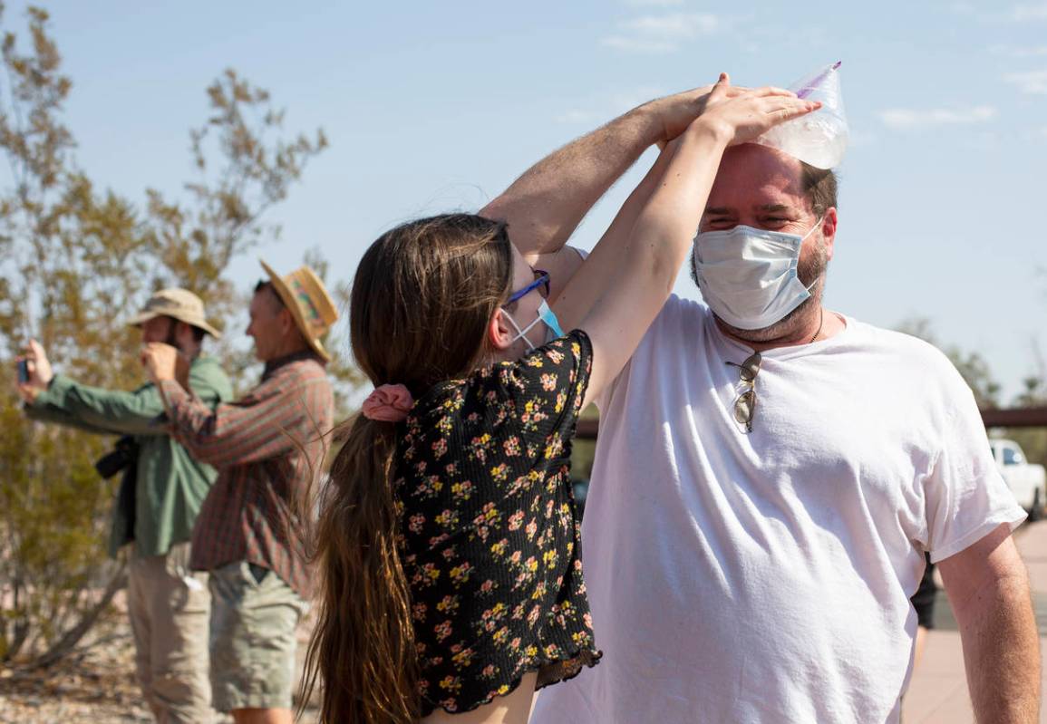 Katie Moore, 12, tries to steal the bag of ice from her father John Moore's head outside Furnac ...