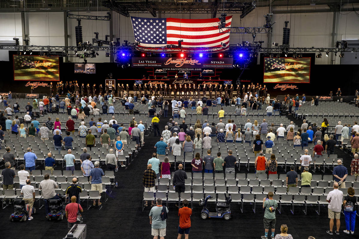 Barrett-Jackson employees stand along with attendees for the National Anthem before the collect ...