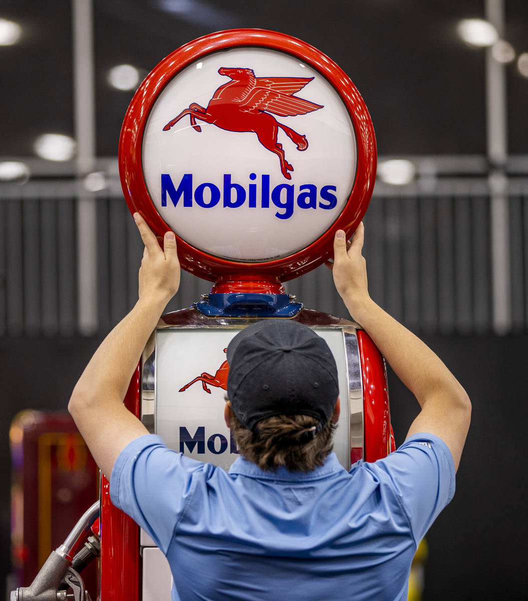 An employee adjusts the lamp atop of a gas pump sold during the Barrett-Jackson collector car a ...