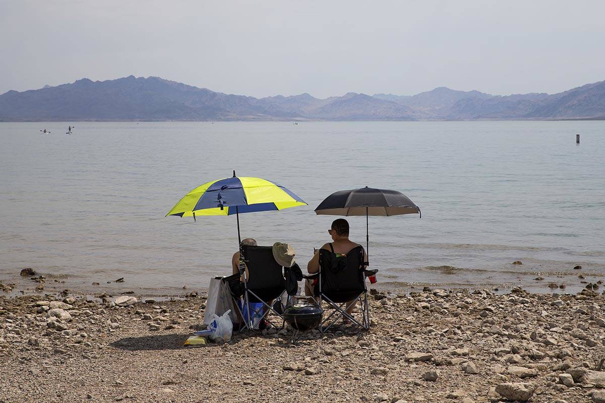 Beach-goers shade themselves under umbrellas along Boulder Beach at Lake Mead on Saturday, June ...