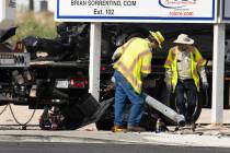 Workers remove a damaged traffic light after a multivehicle crash at the intersection of Warm S ...