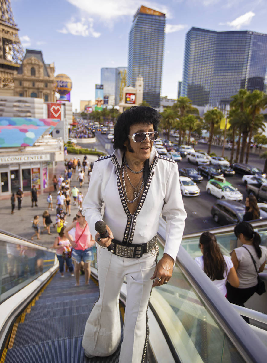 Chris Johnson, known as "Counterfeit Elvis," makes his way up the escalator on the Strip during ...