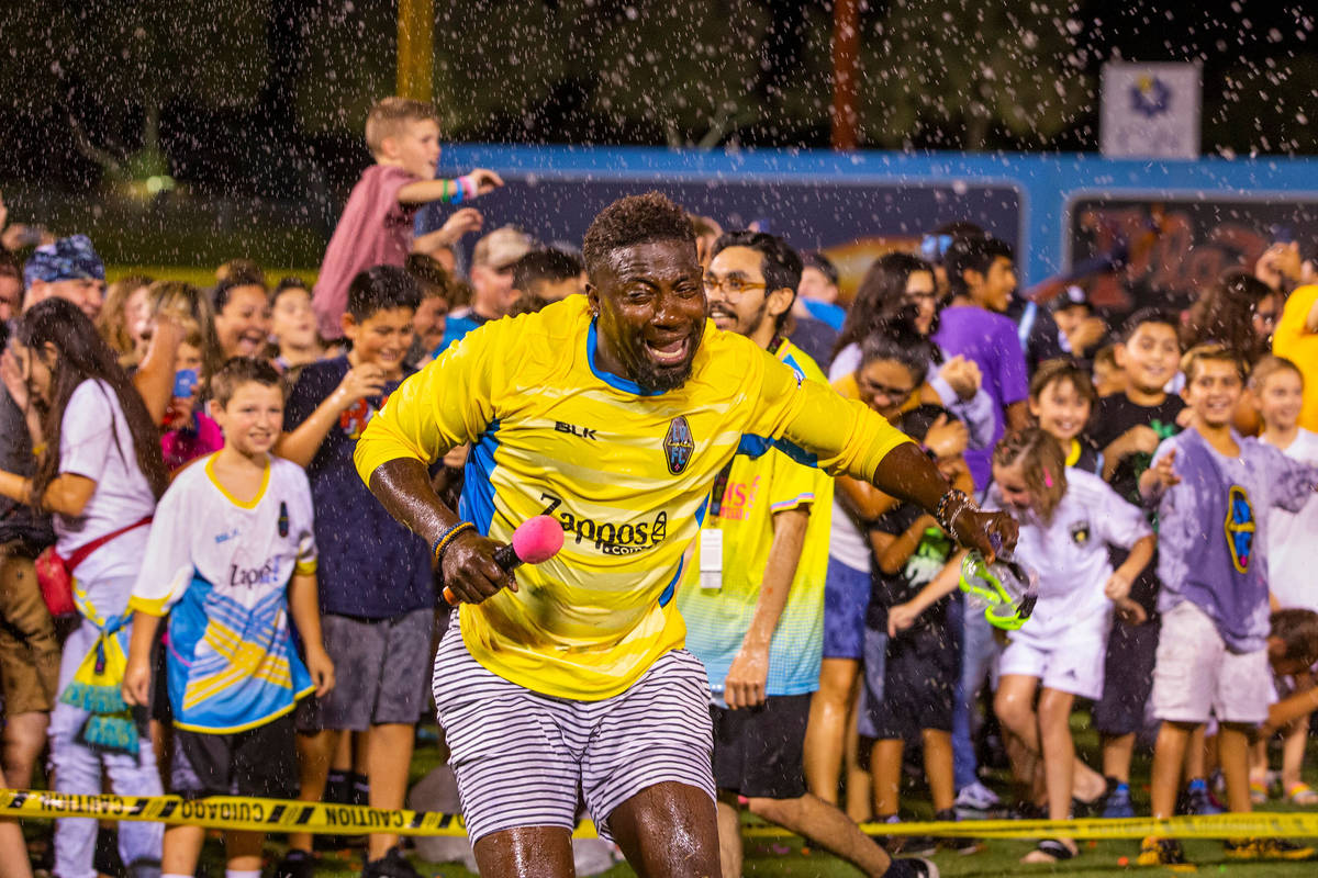 Las Vegas Lights FC hype man Bojo Ackah is pelted as he escapes the fans on field during a mass ...