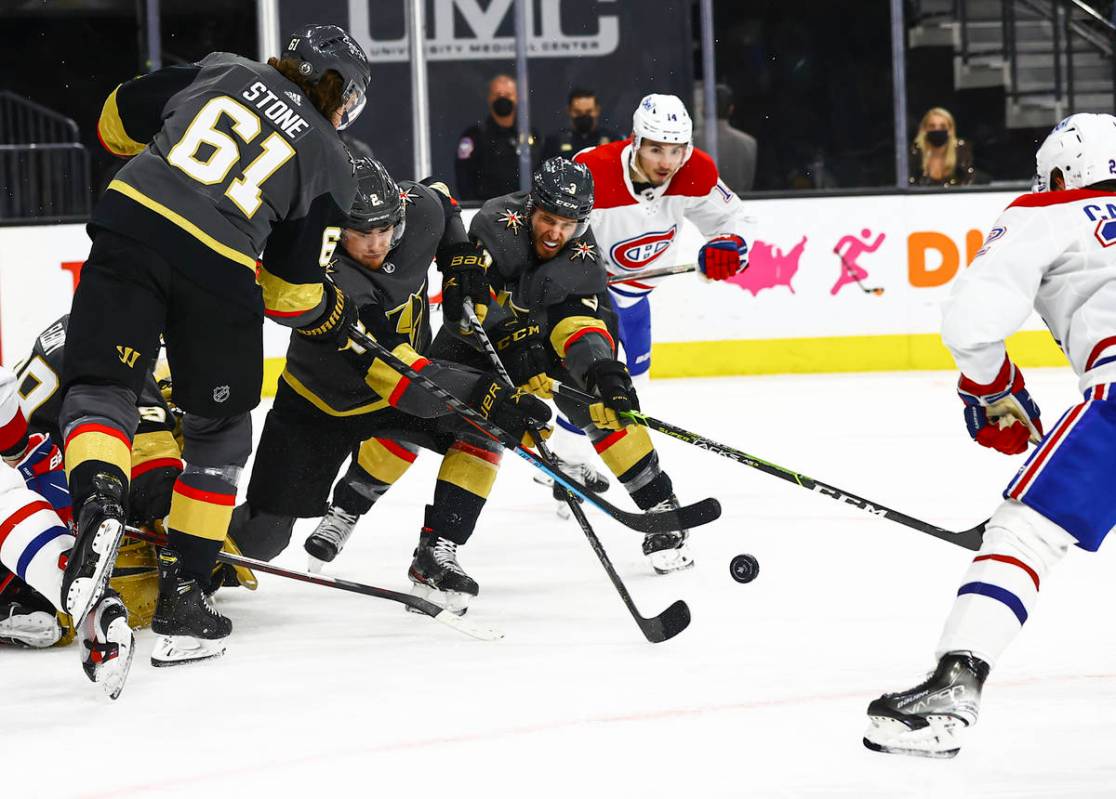 Golden Knights defensemn Zach Whitecloud (2) and Brayden McNabb (3) clear the puck against the ...